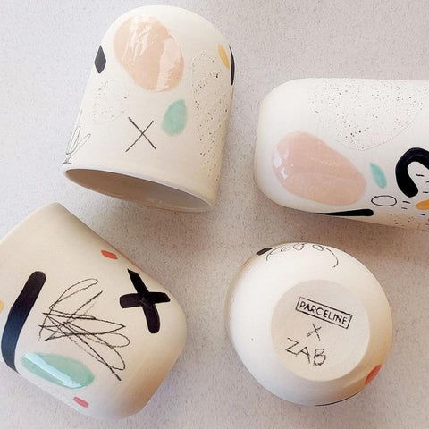 Unique handmade ceramic mugs. Large white mugs with colored patterns.
