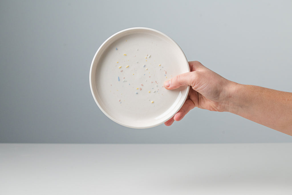 White ceramic plate with colored sparkles.